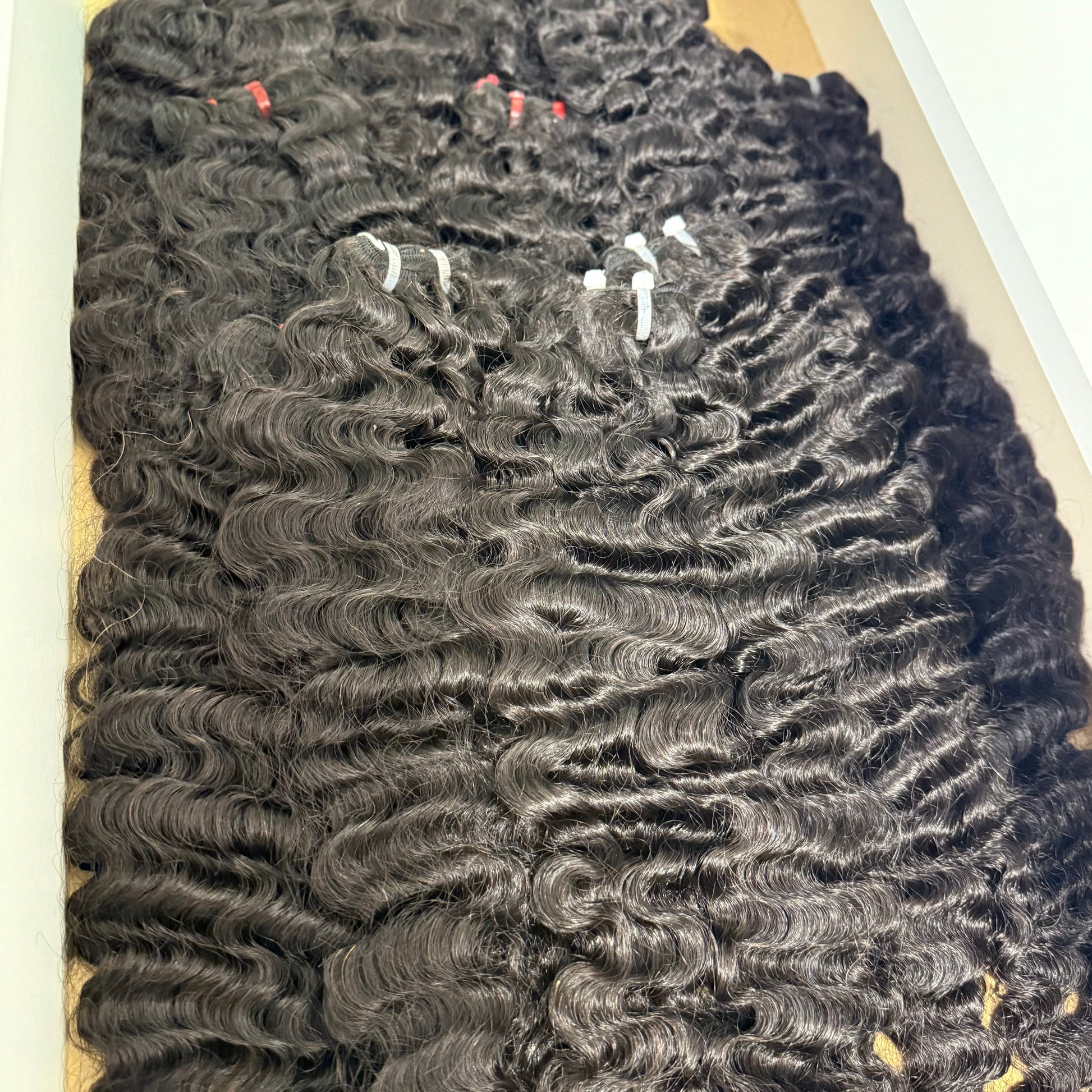 Close-up of Raw Burmese curly hair bundle made with 100% raw human hair extensions for sew-ins, wigs, and protective styles