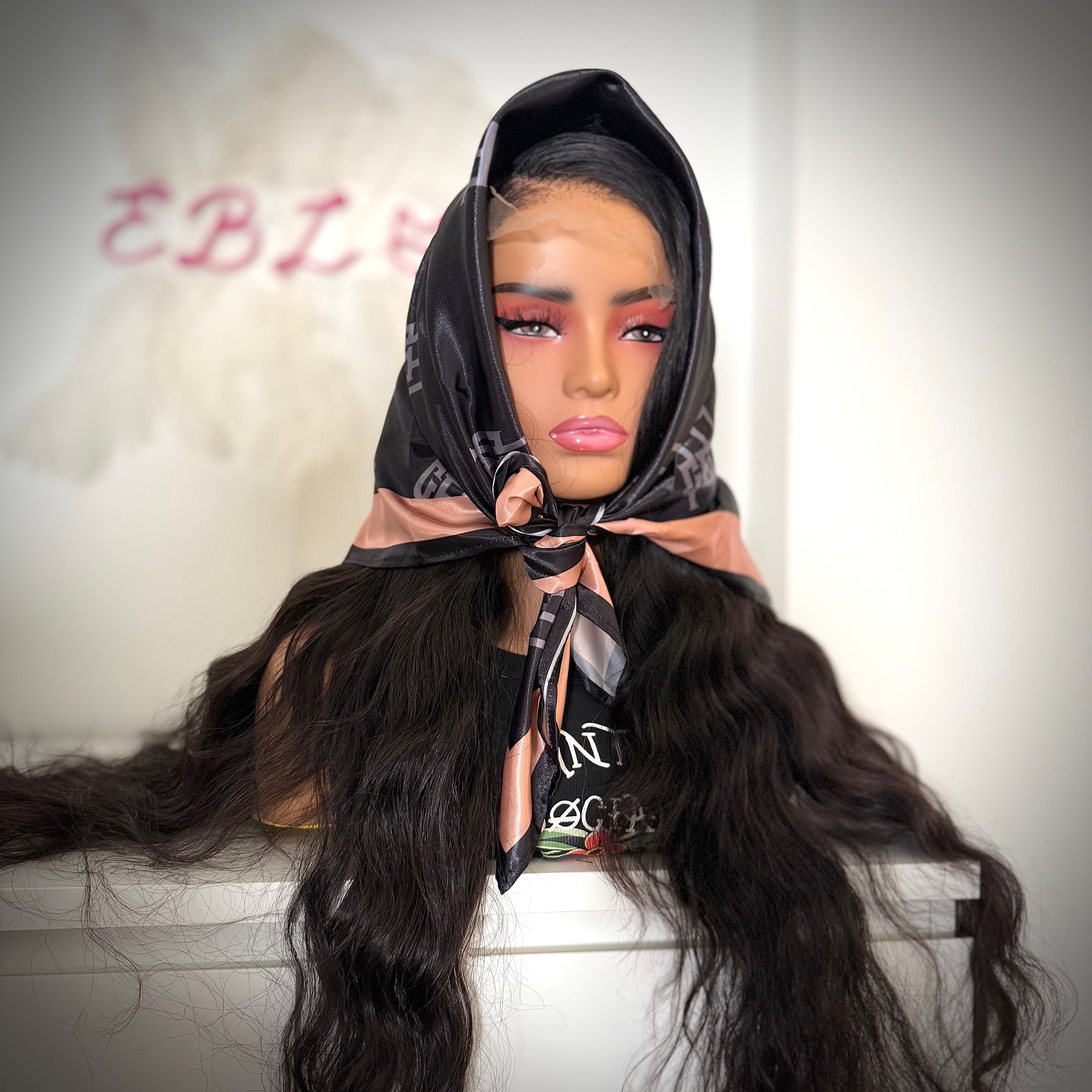Mannequin head with long hair and a scarf, set against a neutral background.