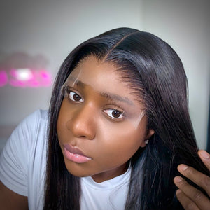 Person wearing a black lace wig with a blurred background