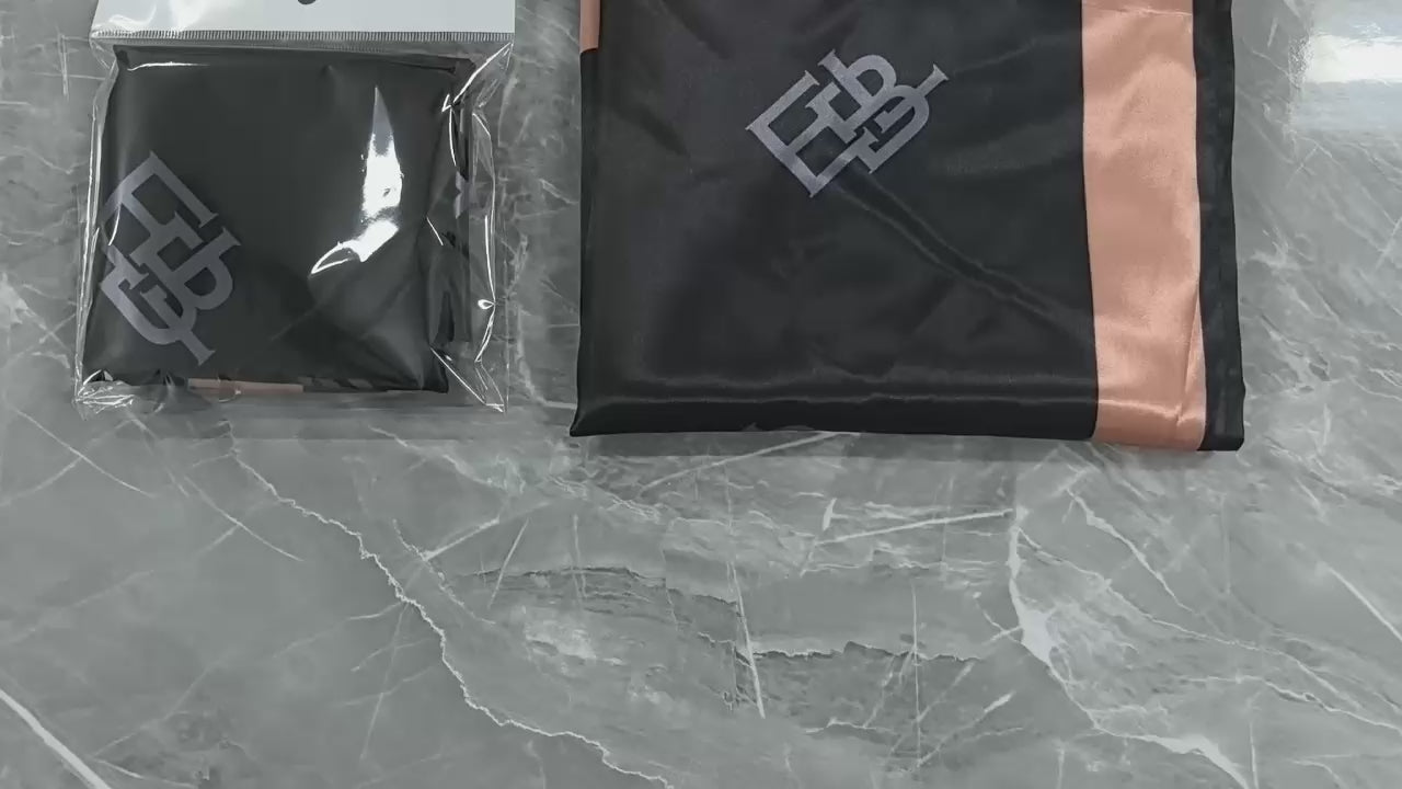 Load video: Person wearing a black headscarf with a logo, against a blurred background.